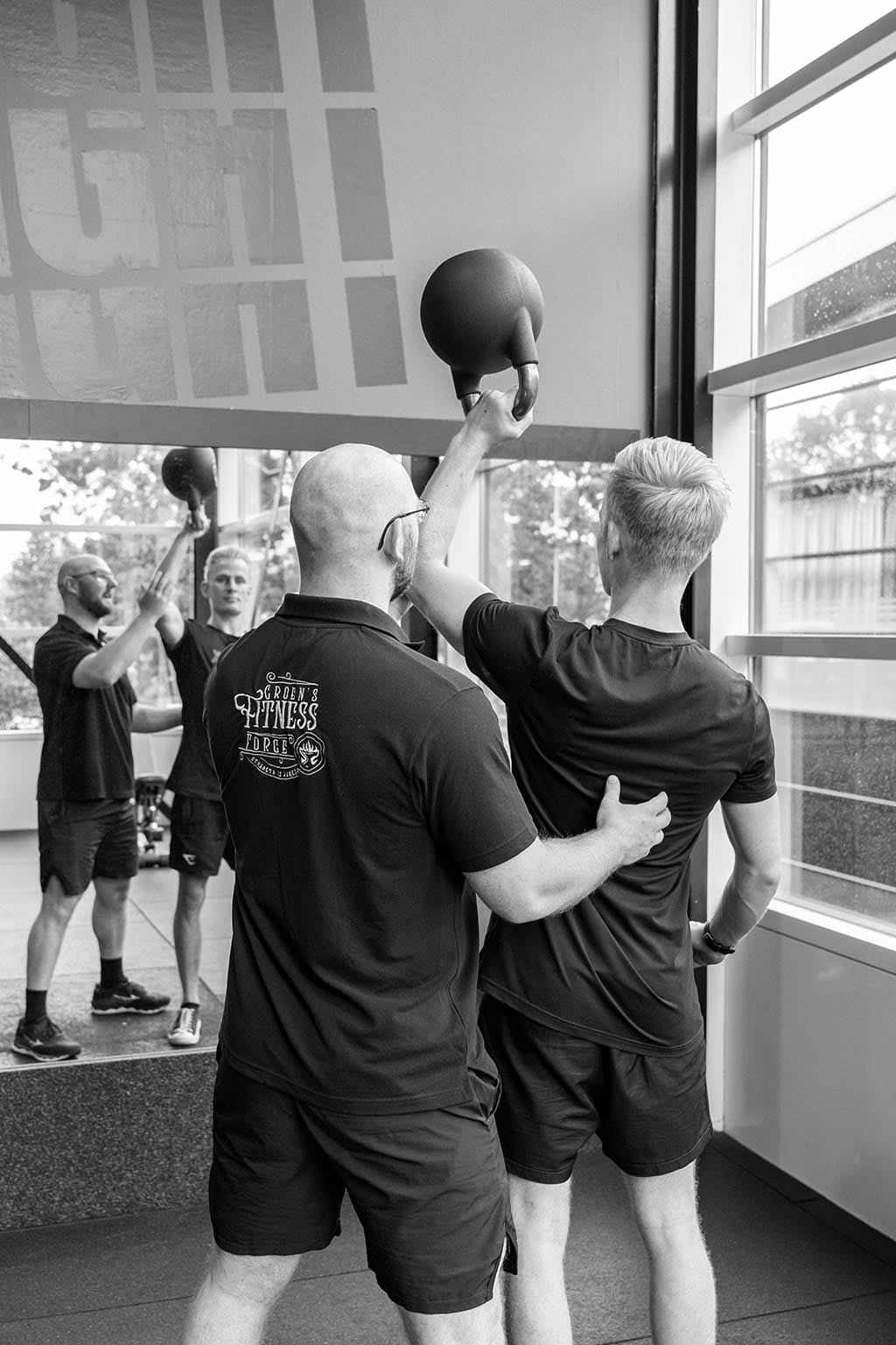 Personal trainer Christiaan Groen demonstreert juiste oefentechniek tijdens 1-op-1 sessie in Heerenveen
